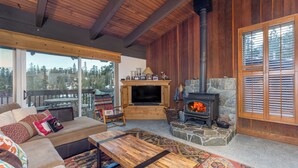 A cozy living room with a large sofa, a coffee table, and a fireplace.
