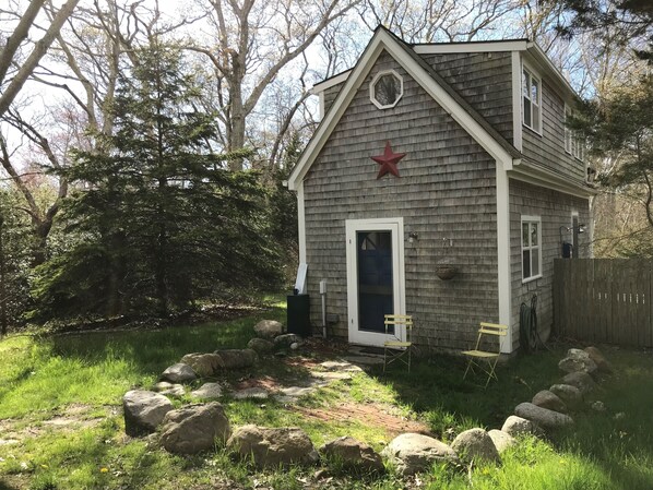 A small, single-story house with a gabled roof and a red star decoration.