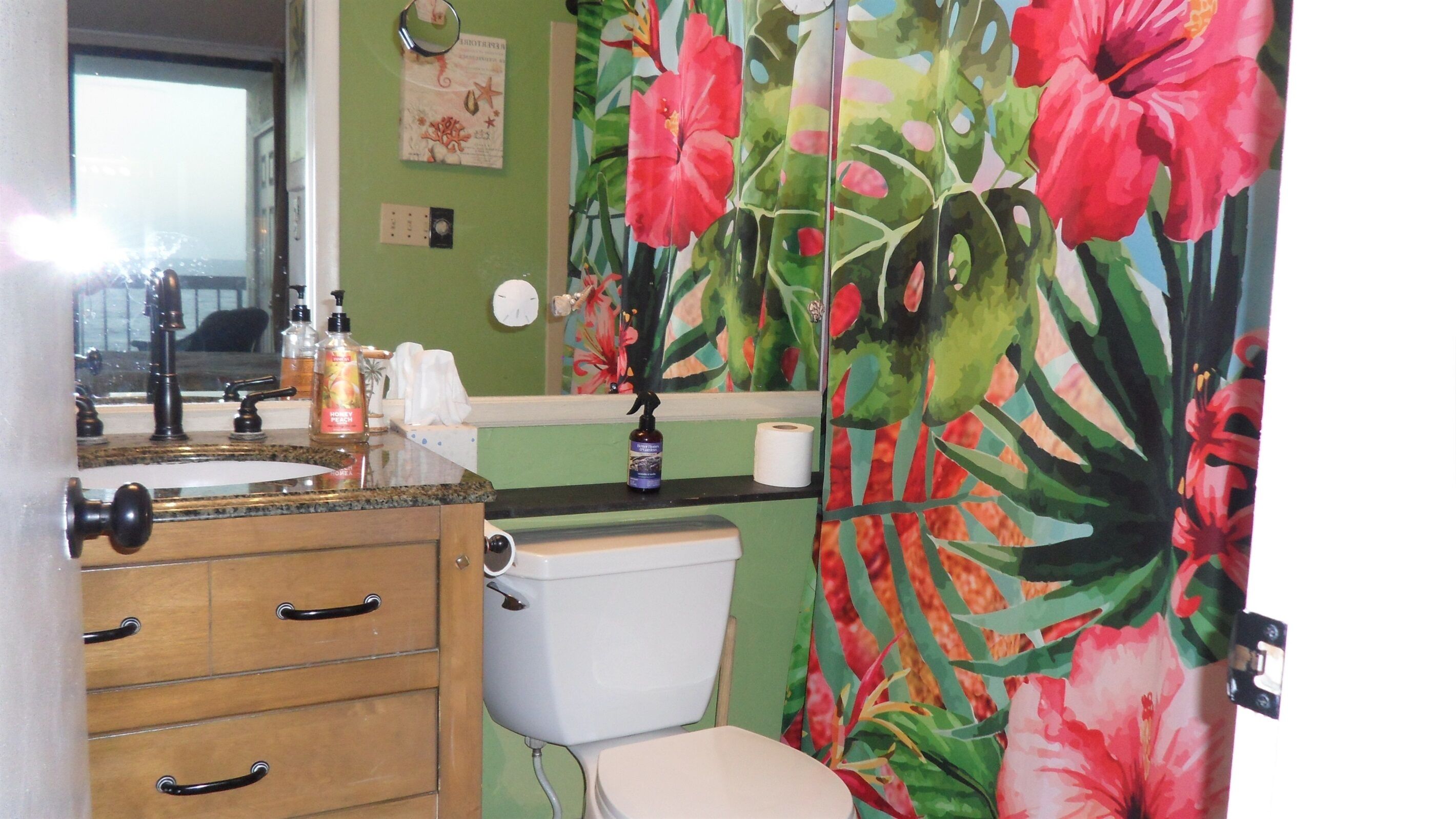 A bathroom with a toilet, sink, and wooden cabinet.