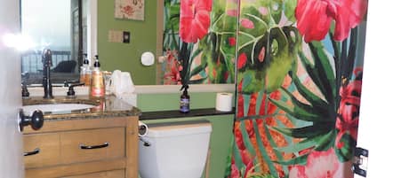 A bathroom with a toilet, sink, and wooden cabinet.
