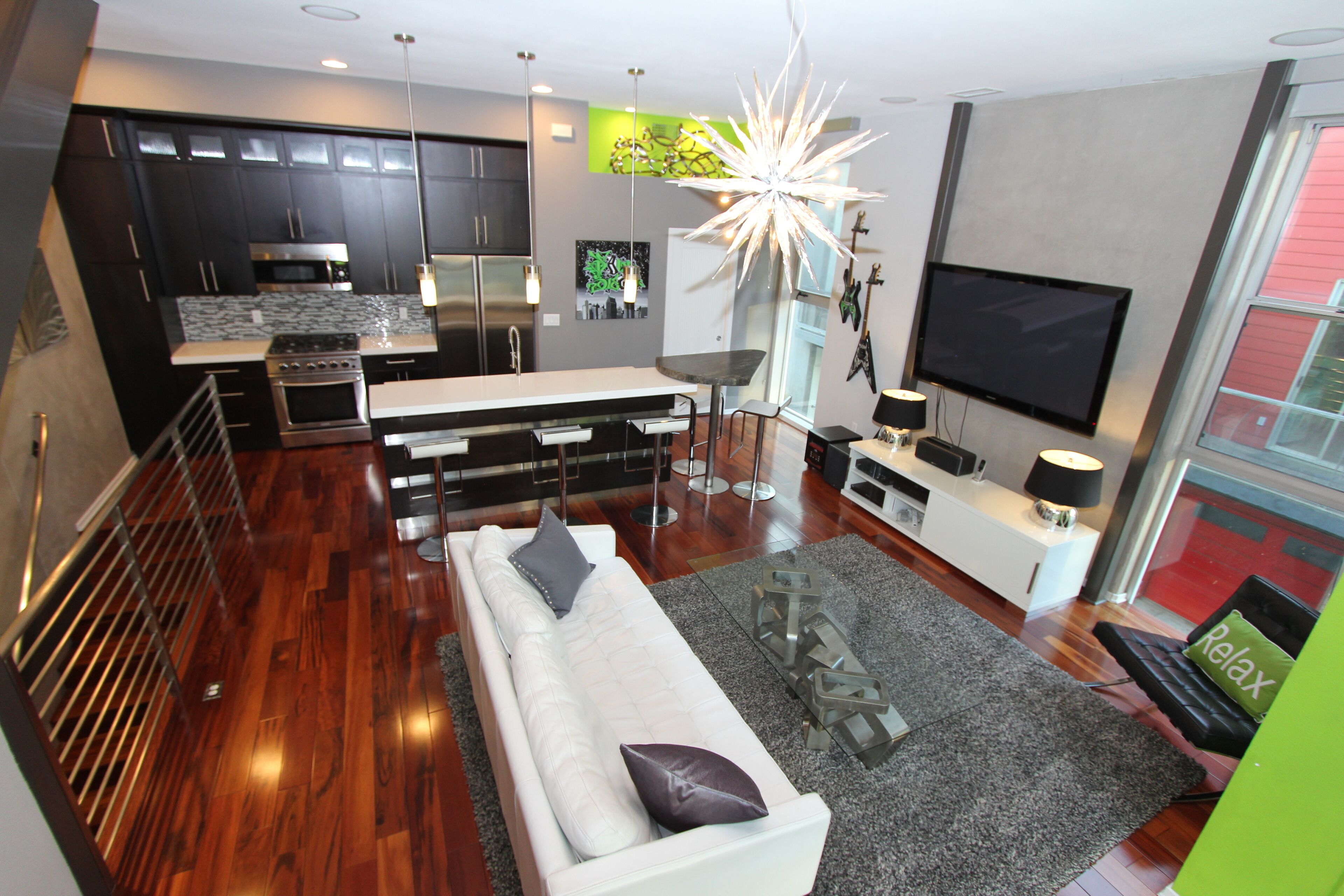 A modern kitchen with dark cabinets, a stainless steel range, and a large window.