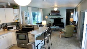 A compact kitchen with a central island, a dining area with chairs, a sofa, a TV, and a fireplace. - 4 BR/3BA Poolhouse is 4 miles from the famous Siesta Key Beach (Sarasota)