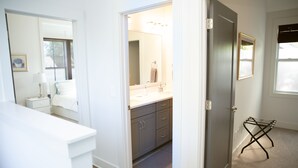 Een badkamer met een wastafel, spiegel en handdoekhouder.