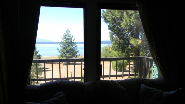 Habitación con cama orientada a un balcón con vista a una playa y al mar.