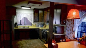 Una cocina compacta con comedor, que incluye un fregadero, cocina y una mesa con sillas.
