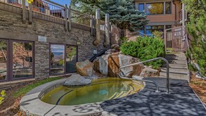 A stone building with a pool, a sign prohibiting smoking, and a staircase leading to a balcony. - Seconds to mall and slope, 2 hot tubs,1 pool, small gym, fireplaces (Snowmass Village)
