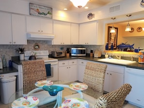 Enjoy cooking in this well-equipped kitchen with stainless steel appliances, a glass-top dining table, and a variety of utensils.