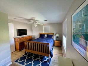 A bedroom with a bed, a desk, a television, a ceiling fan, and a window with blinds. - Beautiful Beachfront Retreat on Broadkill Beach. Perfect for couples & families. (Milton)