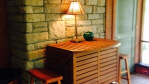 A stone wall, a wooden table with a lamp, a stool, and a cooler. - Ultimate Getaway Lake Cumberland, Great Location, easy access to water (Jamestown)