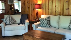 A living room with two white sofas, a wooden coffee table, and a lamp. - Ultimate Getaway Lake Cumberland, Great Location, easy access to water (Jamestown)