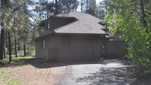 Ein zweigeschossiges Haus mit Satteldach, einer Garage und einer Auffahrt zum Eingang.