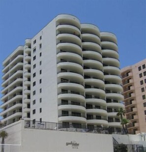A high-rise hotel with multiple balconies, a flat facade, and a sign indicating it is a hotel. - 10/10 EXCEPTIONAL!!!-173 REVIEWS-DAYTONA BEACH-2BD/2BA-RENOVATED-WELL STOCKED (Daytona Beach Shores)