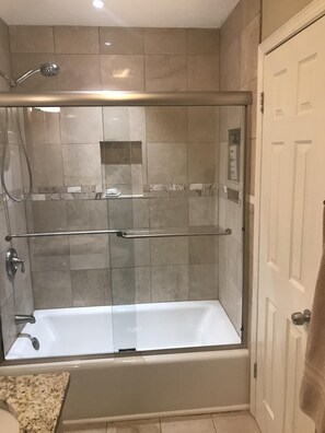 Tina con regadera, secadora de cabello, bidet, toallas 