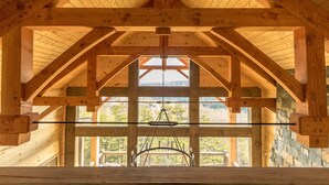 Un intérieur en bois, avec un plafond haut et de grandes fenêtres.