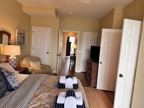 A hotel room with a bed, a TV, a lamp, and a chair.