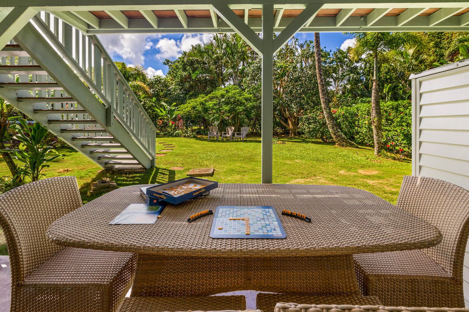 A covered outdoor patio with wicker furniture, a chessboard, and a pizza box.