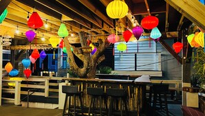 Eine Tiki-Bar mit Holzbalken und hängenden Laternen.
