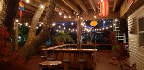 Eine Außenbar mit Holzmöbeln und Lichterketten.