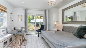 Une chambre moderne avec un grand lit, une table à manger et une vue sur l’extérieur.