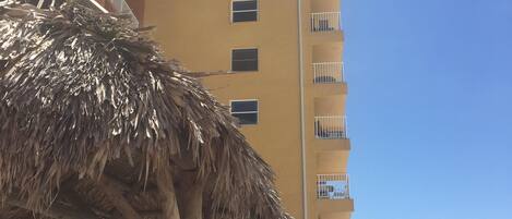 Un hotel de varios pisos con balcones, una zona de piscina y vistas a la playa.