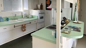 A kitchen with a sink, stove, and refrigerator. - The Getaway 1BR #1: Pool, Mountain View, Kids/Pets welcome (Desert Hot Springs)
