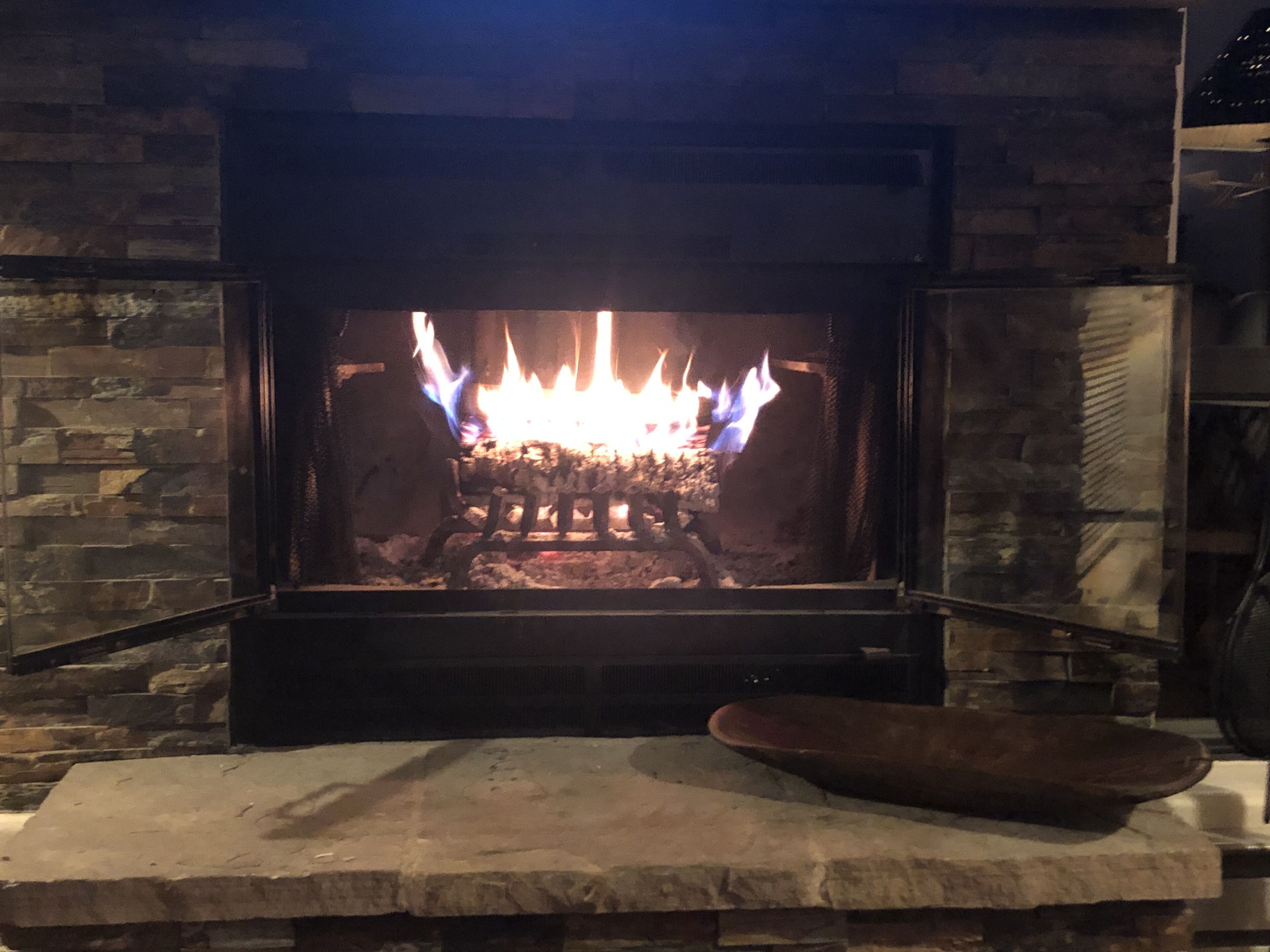 Ein Kamin aus Stein mit brennendem Feuer.