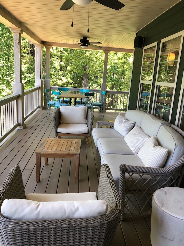 Relax in this inviting outdoor seating area with a central table, sofa, and wicker chairs.
