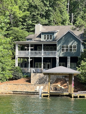 Enjoy waterfront living in this serene two-story house surrounded by lush greenery and a dock.