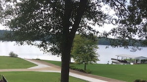 A landscaped area with a paved walkway, a tree, and a view of a lake. - Outdoor family time on the patio, at the pool-pool house, or on the boat dock! (Lexington)