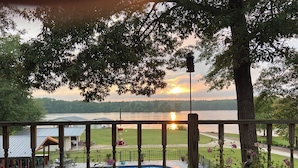 A pool area with a view of a lake and sunset. - Outdoor family time on the patio, at the pool-pool house, or on the boat dock! (Lexington)