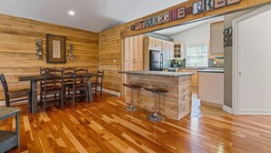 Une cuisine avec des murs en bois, un plancher en bois, un coin bar et un panneau indiquant : « PAS DE PROBLÈMES ».