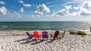 A beach with three Adirondack chairs facing the ocean. - LABOR DAY SPECIALS ,BEACHFRONT, PRIVATE BEACH ON THE WATERFRONT, Bring your Dog (Anna Maria)