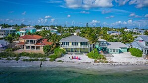 A coastal residential area with houses, a beach, and clear skies. - LABOR DAY SPECIALS ,BEACHFRONT, PRIVATE BEACH ON THE WATERFRONT, Bring your Dog (Anna Maria)