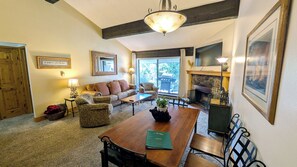 A cozy living room with a fireplace, a dining table, and comfortable seating.