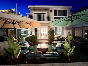 A two-story house with a balcony, outdoor seating area with chairs and a table, and a fire pit. - 70 steps to surf! A+ location! A+ Patio! A+ parking! (San Diego)