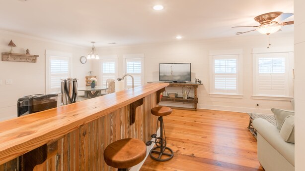 Una cocina amplia con una barra de madera, un comedor y una sala de estar con sofá.