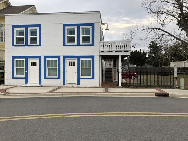 A two-story building with a white facade and blue trim around the windows and doors. - Hang up all your cares and woes and head to Southern Bell with Riverfront views! (St Marys)