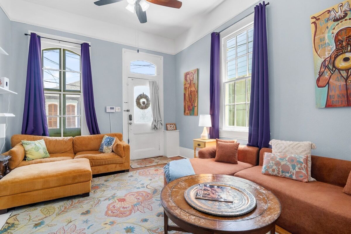 A living room with a sofa set, a coffee table, and a door with a wreath.