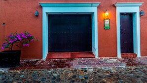 A building with a red exterior, a large black door, and a small entrance with steps.