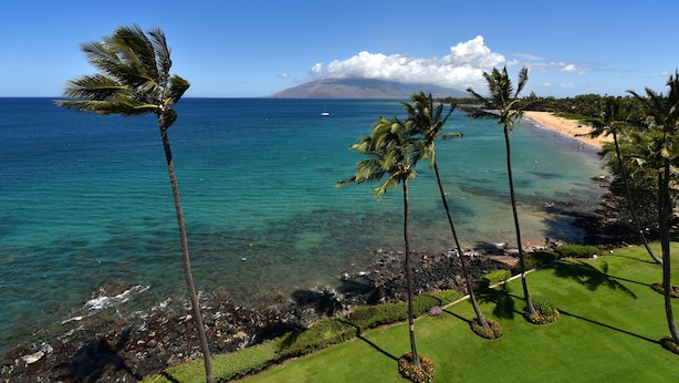 A coastal view with clear blue water, a sandy beach, and a mountain in the background. - Beautiful 2 Bdrm Oceanfront Kihei Condo!  (Kihei)