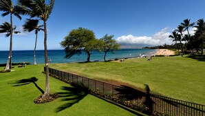 A well-maintained golf course with a clear view of the ocean and a sandy beach in the background. - Beautiful 2 Bdrm Oceanfront Kihei Condo!  (Kihei)
