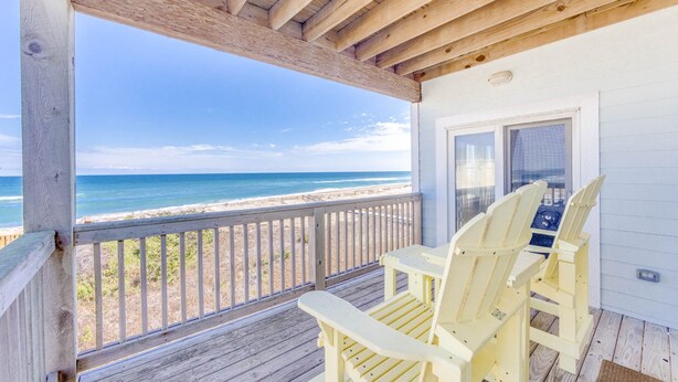 A wooden deck with two chairs overlooking a beach. - Oceanfront Condo w/ Private Sundeck, Resort Pool, Elevator, and Beach Access (Rodanthe)