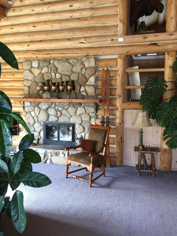 A cozy log cabin interior with a stone fireplace, a wooden chair, and a ladder leading to a loft area. -
Start your exploration of GNP here, easy access to 3 park entrances. (East Glacier Park Village)