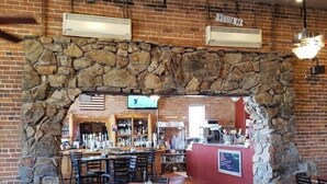 Un restaurante con arcos de piedra, paredes de ladrillo y una zona de bar.