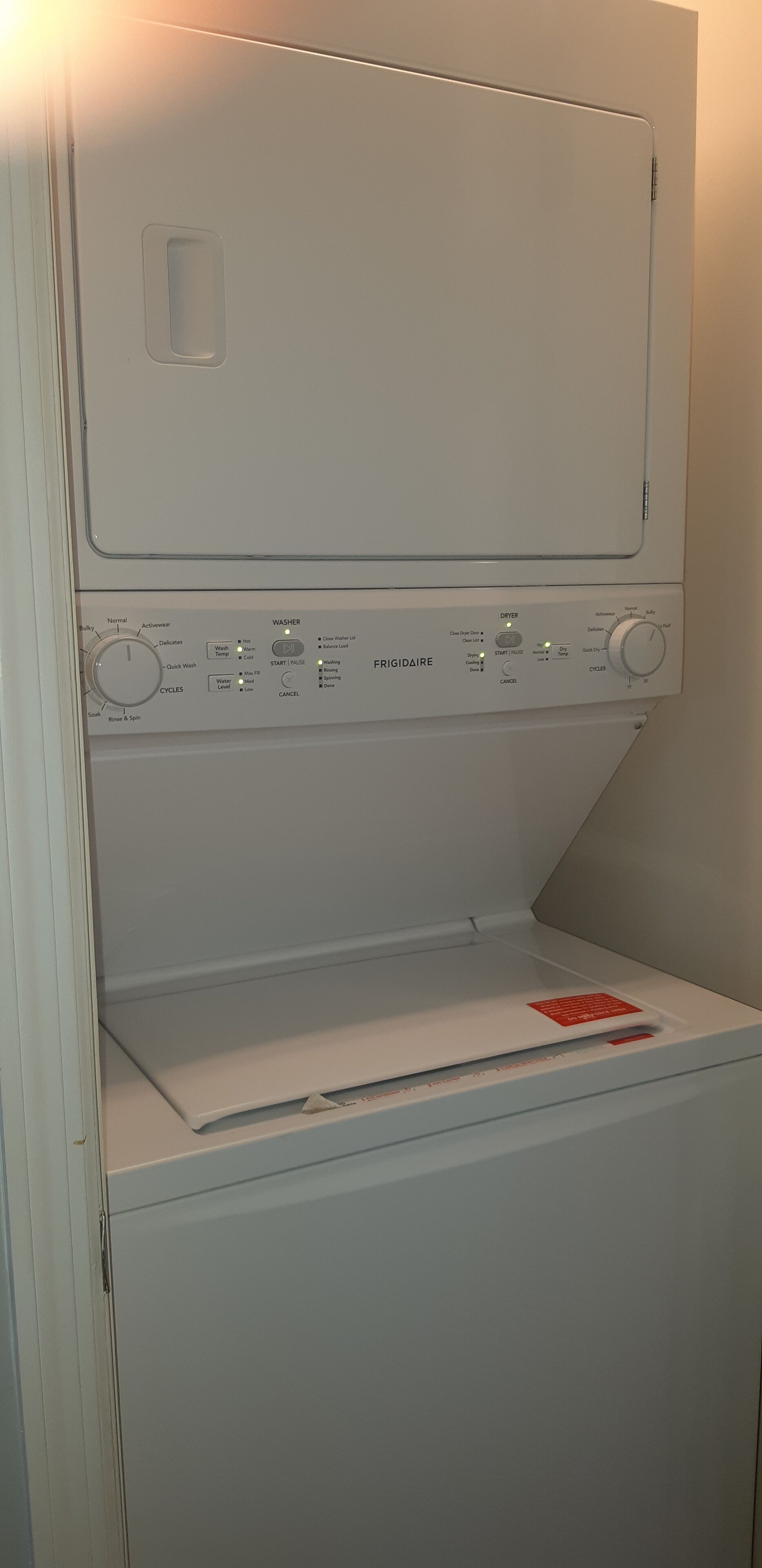 Una lavadora blanca con un panel de control que muestra varios botones y configuraciones.