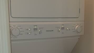 Una lavadora blanca con un panel de control que muestra varios botones y configuraciones.