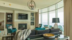 Una sala de estar moderna con chimenea, asientos cómodos y un ventanal con vistas.