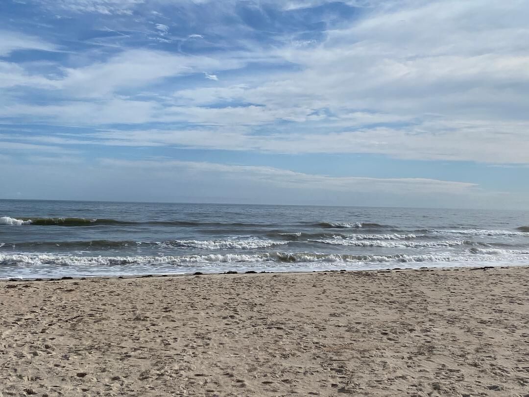 A beach with sand and waves.