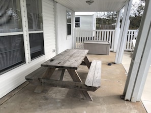 Enjoy a secure outdoor space with a picnic table and benches, adjacent to a building with large windows.