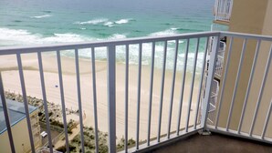 A balcony with a view of the beach and ocean.